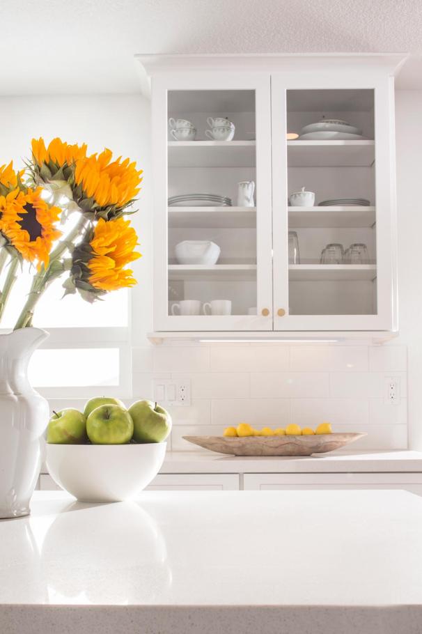Milky white kitchen with green apple and sunflower decoration
