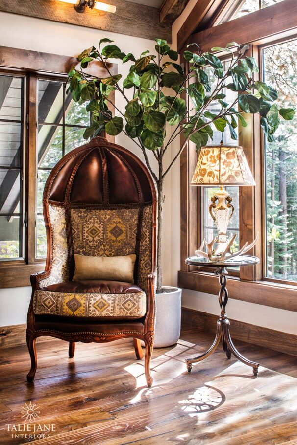 A vintage-style room corner with a grand chair and table lamp