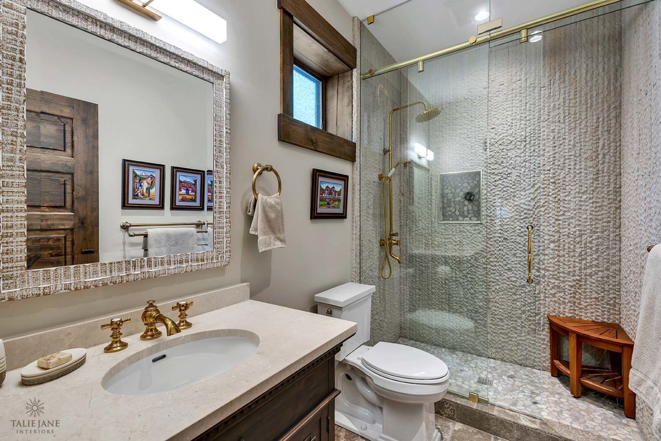 White stone and concrete bathroom with golden bathroom fittings